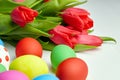 Easter Eggs and red tulip flowers on white wooden table Royalty Free Stock Photo