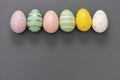 Easter eggs in row, decorative abstract colorful eggs. Over grey background, top view Royalty Free Stock Photo