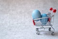 Easter eggs in a shopping cart on gray concrete background Royalty Free Stock Photo