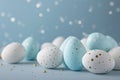 Pastel light blue colour Easter eggs in soft blue and white with gold speckles rest on a blue background. The cheerful Royalty Free Stock Photo