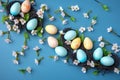 Easter eggs and sprig flowers on blue background. Generative Ai
