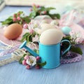 Easter eggs, spring flowers and lace ribbons on a wooden table