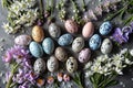 Easter eggs and spring flowers on a stone background, top view Royalty Free Stock Photo