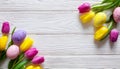 Colorful Easter eggs and lovely spring flowers on wooden background. Top view with copy space Royalty Free Stock Photo