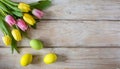 Colorful Easter eggs and lovely spring flowers on wooden background. Top view with copy space Royalty Free Stock Photo