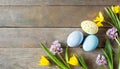Colorful Easter eggs and lovely spring flowers on wooden background. Top view with copy space Royalty Free Stock Photo