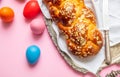 Easter eggs and tsoureki braid, greek easter sweet bread, on pink color background Royalty Free Stock Photo