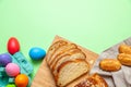Easter eggs and tsoureki braid, greek easter sweet bread, on green pastel Royalty Free Stock Photo