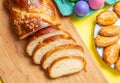 Easter eggs and tsoureki braid, greek easter sweet bread, on yellow color background Royalty Free Stock Photo