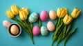 Pastel colored Easter eggs and yellow tulips arranged on a blue background Royalty Free Stock Photo