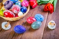 Easter eggs with tulips on weathered wooden background