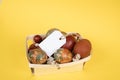 Easter eggs with varied natural patterns in a small wooden basket with a blank tag Royalty Free Stock Photo