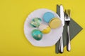Easter eggs in a  plate near a napkin and a knife and fork on a yellow background Royalty Free Stock Photo