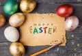 Easter eggs on wooden table with happy easter lettering.