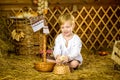 Easter fairy tale, a boy with chickens playing in a barn. Royalty Free Stock Photo