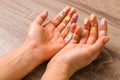 Easter and feminity concept. closeup woman hands dirty by goache paint with multicolor spots over a wooden table