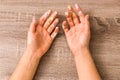 Easter and feminity concept. closeup woman hands dirty by goache paint with multicolor spots over a wooden table