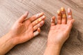 Easter and feminity concept. closeup woman hands dirty by goache paint with multicolor spots over a wooden table Royalty Free Stock Photo