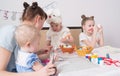 Easter Festival: The family at the table prepare for the holiday. Daughter put a pattern on the egg. Royalty Free Stock Photo