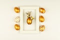 Easter festive decoration. Top view of easter eggs colored with golden paint and empty mock-up photo frame. Various dotted designs