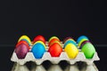 Easter festive multicolor eggs carton, black background