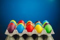 Easter festive multicolor eggs carton, blue background Royalty Free Stock Photo