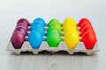 Easter festive multicolor eggs carton, light gray wooden background Royalty Free Stock Photo