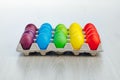 Easter festive multicolor eggs carton, light gray wooden background Royalty Free Stock Photo