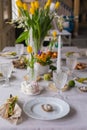 Easter festive spring table setting decoration, eggs in nest, fresh yellow tulips, marshmallows, selective focus Royalty Free Stock Photo