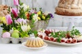 Easter festive table with food and spring floral arrangements