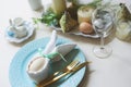 Easter festive table. Guest dining place decorated with bunny napkin and egg