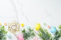Easter composition with colored eggs and green plants on white background. Royalty Free Stock Photo