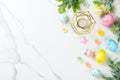 Easter composition with colored eggs and green plants on white background. Royalty Free Stock Photo