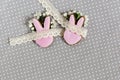 Easter flat lay of Easter gingerbread bunny shape with lace and blooming flowers and tablecloth. Grey polka dot fabric background