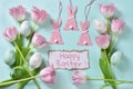 Easter flat lay with pink tulips and decors on mint background