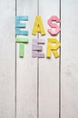 Easter folded paper origami colorful lettering on white wooden planks rustic background