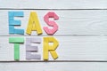 Easter folded paper origami colorful lettering on white wooden planks rustic background