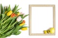 Easter frame with a bouquet of tulip flowers and yellow eggs on a white background. Copy space, top view Royalty Free Stock Photo