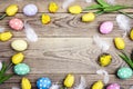 Easter frame with colored eggs, feathers and tulip on old wooden Royalty Free Stock Photo
