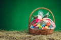 Easter gift basket with multicolor eggs, green background