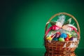 Easter gift basket with multicolor eggs, green background