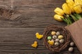 Easter gingerbread cookies on wooden table and yellow tulips. Greeting card. Top view with copy space