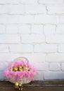 Easter gold eggs in white wooden basket with pink feathers near gold rabbit Royalty Free Stock Photo