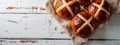 Easter. Good Friday. Hot cross buns on a white wooden background. Top view.