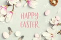 Easter greeting card with beautiful spring magnolia flowers and Easter decoration on grey stone background. Easter