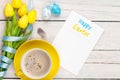 Easter greeting card with blue and white eggs, yellow tulips and