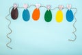 Easter greeting card made of Easter eggs cut out of their multi-colored paper hanging on a rope on clothespins Royalty Free Stock Photo