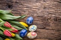 Easter. Hand made easter eggs and spring tulips on old wooden table