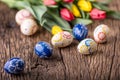 Easter. Hand made easter eggs and spring tulips on old wooden table