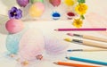 Easter hand-painted eggs with colored pencils,watercolors and spring flowers,arranged on colored drawing. Royalty Free Stock Photo